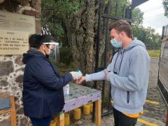 Hombre toma gel antibacterial de manos del personal de entrada, Teotihucán. Fotografía: Facebook Teotihuacan en casa.