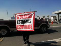 Operador de camión sostiene lona "Apoyanos estamos desempleados", en caceta de cobro. Fotografía: Isaías Hernández Rosales.