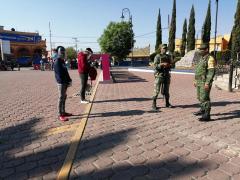 Dos jóvenes; uno de sudadera azul y otro con sudadera roja, frente a dos militares, San Martín de las Pirámides, Edomex.. Fotografía: Isaías Hernández Rosales