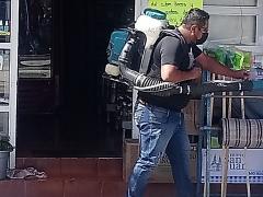 Hombre sanitizando las afueras de un negocio. Fotografía: San Lorenzo Tlalmimilolpan