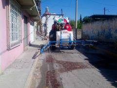 Tractor que sanitiza la calle; sobre el piso la marca del sanitizante. Fotografía: San Lorenzo Tlalmimilolpan