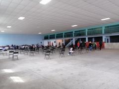 Personas de la tercera edad esperan sentadas dentro del Auditorio Ejidal de Jaltepec II. Fotografía: Isaías Hernández Rosales.