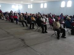 Personas de la tercera edad esperan sentadas dentro del Auditorio Ejidal de Jaltepec IV. Fotografía: Isaías Hernández Rosales.