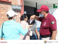 Elemento de Protección Civil aplica gel a mujer en la entrada del auditorio. Fotografía: Gobierno Municipal de Teotihuacán.