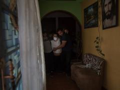 Los hijos del enfermo, sin cubrebocas, lo sacan del cuarto. Fotografía: Seila Montes