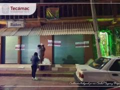 Personal coloca sellos de suspensión de actividades en las cortinas del bar. Fotografía: Facebook Tecámac Centro.