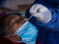 Mujer de la tercera edad, aplicándole prueba del COVID-19.