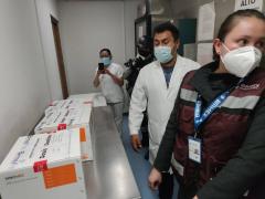 Personal de Salud y sobre una mesa tres cajas con dosis de la vacuna Sinovac. Fotografía: Fernando Vilchis.