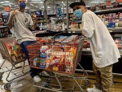 Ángel Quezada en supermercado comprando víveres para despensas.
