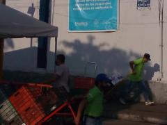 Cargadores frente a lona impresa sobre el uso obligatorio de cubrebocas, Mercado de Abastos, Guadalajara. Fotografía: Juan José Carrillo Coronel.