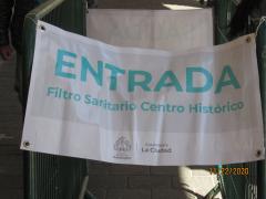 Lona "ENTRADA. FILTRO SANITARIO CENTRO HISTÓRICO", Fotografía de jóvenes encargados de tomar temperatura y entregar gel antibacterial, Centro Histórico, Guadalajara. Fotografía: Juan José Carrillo Coronel