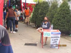 Empleada del tianguis con cubrebocas provee de gel y toma temperatura a los clientes. Fotografía: Juan José Carrillo Coronel.