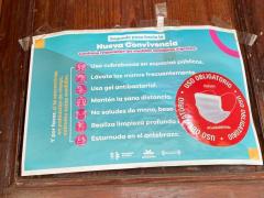Cartel Segundo paso hacia la Nueva Covivencia. Continúa respetando las medidas sanitarias vigentes. Fotografía: Gloria Elisa Melgarejo García.