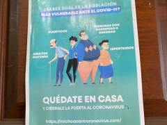 Póster con cuatro personas en caricatura portando cubrebocas e informando quiénes son los más vulnerables al COVID-19. Fotografía: Gloria Elisa Melgarejo García