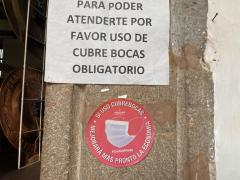 Letrero y etiqueta sobre obligatoriedad del cubrebocas para prevenir el COVID-19. Fotografía: Gloria Elisa Melgarejo García.