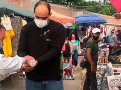 Silvano Aureoles le proporcionan gel antibacterial en tianguis. Fotografía: Cortesía MiMorelia.