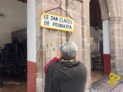 Maestra coloca su letrero, Portal San Agustín, Morelia. Fotografía: Eliza Flores.