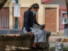 Mujer con cubrebocas centada en una fuente, Morelia. Fotografía: Carmen Hernández.