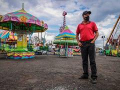 Jaime López frente a los juegos mecánicos de fondo. Fotografía: Fernando Maldonado.