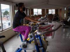 Usuaria de gimnasio hace ejercicio en la bicicleta estática. Fotografía: Iván Arias.