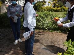 Jornada de vacunación, mujer aplica desinfectante (con sales cuaternarias de amonio), antes de ingresar a la explanada municipal de San Pablo Huitzo. Fotografía: Ángel López González.