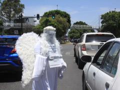 Ángel con careta entre automovilistas, "Artistas urbanos en tiempos de coronavirus". Fotografía: Bibiana Díaz.