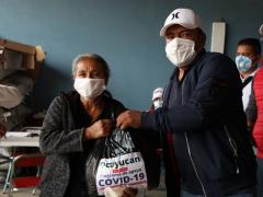 Mujer de la tercera edad recibe despensa de manos del presidente municipal, Programa de apoyo COVID-19. Fotografía: Ayuntamiento de Ocoyucan