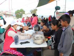 Personal del ayuntamiento de Ocoyucan, entrega despensa a mujer con su hijo, Programa de apoyo COVID-19. Fotografía: Ayuntamiento de Ocoyucan.