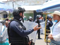 Elemento de seguridad pública platica con un transeúnte. Fotografía: El Sol de Puebla.