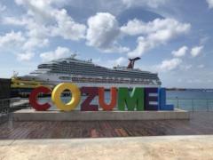Letrero "Cozumel" y al fondo un crucero.