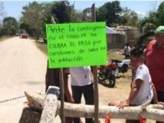 Personas bloquean acceso a un poblado con el cartel "Ante la contigencia por el COVID-19 se cierra el paso...". Fotografía: El Vigilante de Quintana Roo.
