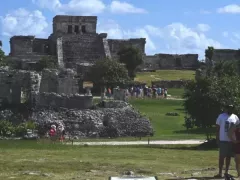 Turistas con cubrebocas frente a ruinas arqueológicas