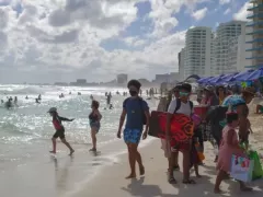 Turistas con cubrebocas en playa