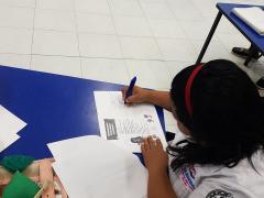 Maestra escribiendo. Fotografía: Facebook DIF Solidaridad.