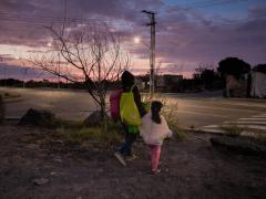 Briana Villafuerte Caltzontzi, alumna de tercer año de preescolar en la Escuela Pública Juventino Rosas, cruza una avenida en Santiago de Querétaro junto a su madre rumbo al Centro Histórico de Querétaro. Fotografía: Selene Ugalde.