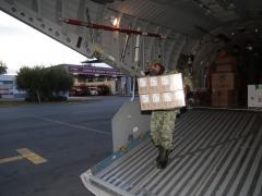 Soldado del ejército bajando parte del cargamento de vacunas