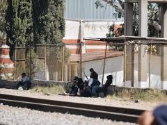 Migrantes a la orilla de una vías. Fotografía: Juanita Olivo.