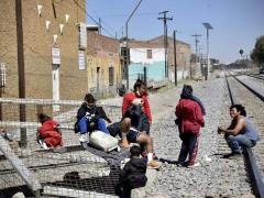 Grupo de migrantes a orilla de la vía. Migrantes a la orilla de una vías. Fotografía: Norma Rivera.