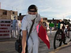 Enfermera con pancarta coloca cofia durante manifestación, Hospital General de Soledad. Fotografía: Pulso. Diario de San Luis.