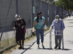 Mujer acompaña a dos personas de la tercera edad. Fotografía: Norma Rivera.