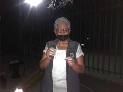 Mujer en la fila para vacunarse muestra su turno. Fotografía: Wendy Jiménez.