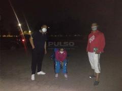 Dos hombres acompañan a un hombre de edad mayor en la fila para vacunarse. Fotografía: Wendy Jiménez.