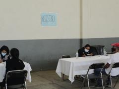Mesas de registro, del lado izquierdo una mujer, de lado derecho un hombre, Papalotla, Tlaxcala. Fotografía: Joshua Vázquez Rugerio.