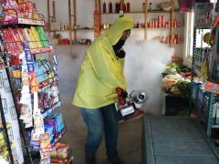 Persona fumiga productos de una tienda, Chavarrillo, Veracruz. Fotografía: Erika Contreras de La Mora.