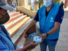 Estudiante, parte del Programa de Vacunación en Yucatán, reparte cubrebocas. Fotografía: Facebook Jairo Calderon Moguel.