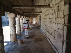 Trabajador sanitiza zona arqueológica en Yucatán. Fotografía: La Jornada Maya.