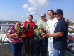 Grupo de personas con macetas de plantas y flores, Yucatán. Fotografía: Juan Manuel Contreras.