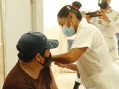 Enfermera vacuna con segunda dosis AstraZeneca a hombre de gorra. Fotografía: Facebook Mauricio Vila.