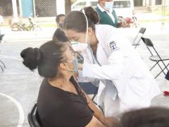 Enfermera vacuna con segunda dosis AstraZeneca a mujer con blusa negra. Fotografía: Facebook Mauricio Vila.