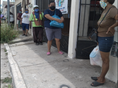 Fila de gente espera recibir comida en el Comedor comunitario de Villas Oriente, Yucatán.